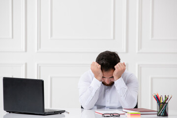 Fototapeta premium ADHD office cute young worker at work behind the desk with the computer tired holding head