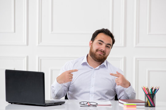 ADHD brunette young office worker at work behind the desk with the computer pointing at himself