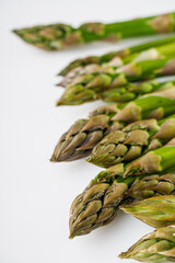raw green asparagus on a white acrylic background