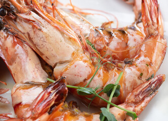 Fried shrimp with herbs on a white plate. Selective Focus.