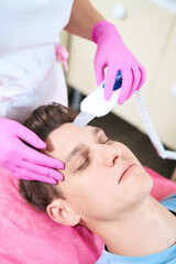 Obraz na płótnie Canvas Calm man relaxing during beauty procedures in clinic