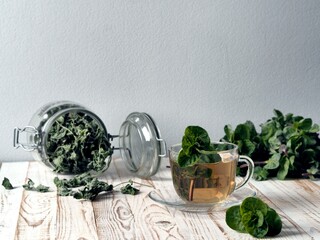 Cups with medicinal mint tea with a bunch of fresh mint and a teapot on a gray background. Herbal tea.