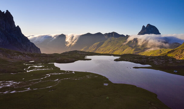 Aerial image of the Anayet lake with the pic of Midi d'Ossau in the background and clouds coming from the north