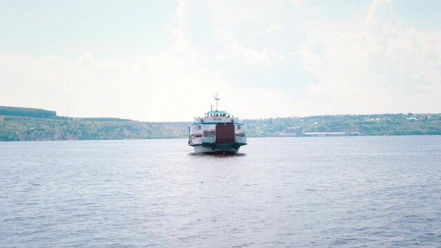 A white ferry with a Russian flag is approaching the shore. transportation of passengers