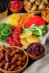 set of various dried fruits on a black wooden rustic background