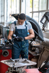 Vehicle mechanic using the equipment for measuring the tyre pressure