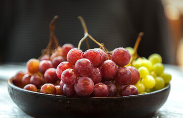 UVAS ROJAS Y VERDES SOBRE MADERA CON COPA DE VINO