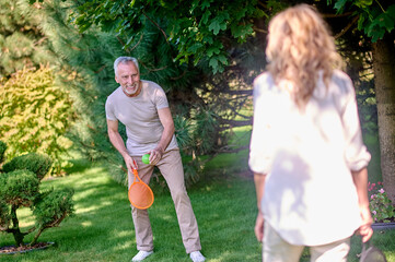 Mature couple looking enjoyed while playing tennis in the park