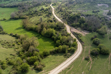 Vista de dron de un paisaje verde con sendero de media montaña en primavera