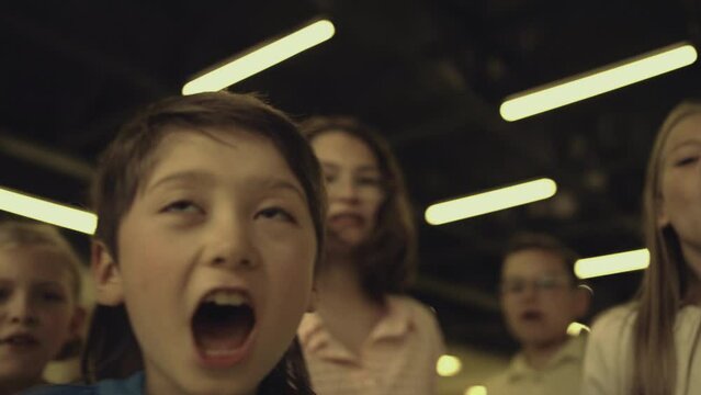 Shouting pupils teasing schoolchild in school hall close up. Children mocking.