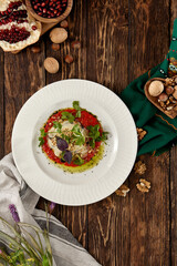 Hot appetizer - baked eggplant with cheese and tomatoes. Stuffed eggplants with mozzarella cheese and tomato sauce in rustic style. Eggplant and cheese appetizer on white plate in italian style.