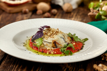 Hot appetizer - baked eggplant with cheese and tomatoes. Stuffed eggplants with mozzarella cheese and tomato sauce in rustic style. Eggplant and cheese appetizer on white plate in italian style.