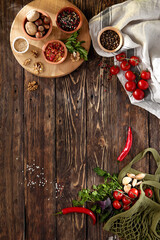 Dark wooden background with fresh vegetables and spices in georgian style. Composition with food ingredients and textile. Food background in rustic style with cherry tomatoes, fresh herbs, nuts