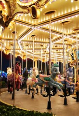 Vertical shot of an illuminated carousel merry-go-round ride for kids with animals
