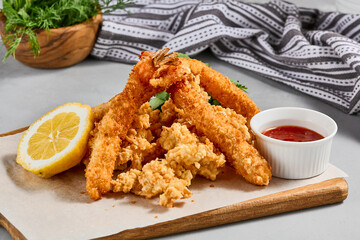 Traditional asian appetizer - crispy shrimps with sauce. Tempura shrimps on wooden board. Prawn tempura in panko breaded with spicy sauce. Pan asian food. Summer menu.