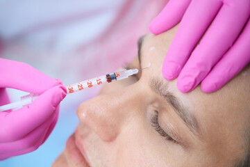Obraz na płótnie Canvas Calm man doing antiage injections in beauty salon