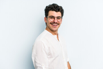 Young caucasian man isolated on blue background confident keeping hands on hips.