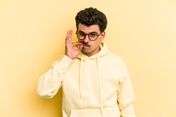 Fototapeta premium Young caucasian man isolated on yellow background with fingers on lips keeping a secret.