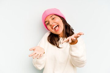 Young hispanic woman isolated on blue background being shocked because of something she has seen.