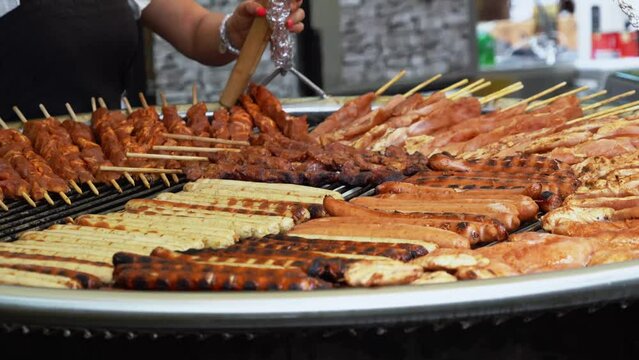 Rotating Grill At A Folk Festival With Bratwurst, Kielbasa, Ham Sausage, Turkey Kebabs And Pork Is Rotated And Refilled