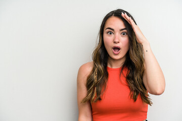 Young caucasian woman isolated on white background shouts loud, keeps eyes opened and hands tense.