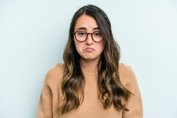 Young caucasian woman isolated on blue background sad, serious face, feeling miserable and...