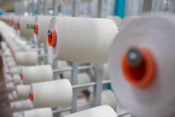 Textile industry - spools of yarn on spinning machine in a textile factory