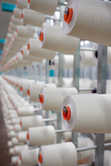 Textile industry - spools of yarn on spinning machine in a textile factory