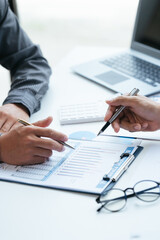 Group of business people meeting, discussing, analyzing graphs, financial data, and planning a marketing project together