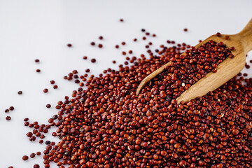 red quinoa seeds on a white acrylic background