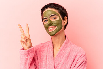 Young caucasian woman wearing a face mask isolated on pink background showing number two with fingers.