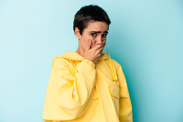 Young caucasian woman isolated on blue background scared and afraid.