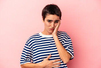 Young caucasian woman isolated on blue background blows cheeks, has tired expression. Facial...