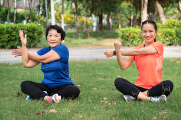 Asia senior and teenager woman training stretching at garden	