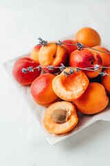 close-up on apricots with a sprig of lavender on a white background