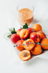 .close-up on ripe apricots and apricot smoothie on white background