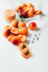 close-up on ripe apricots and apricot smoothie on white background