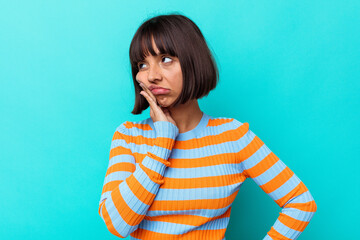 Young mixed race woman isolated on blue background who is bored, fatigued and need a relax day.