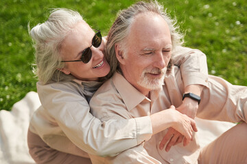 Happy mature couple sitting on the grass