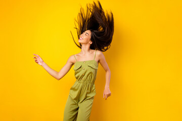 Portrait of gorgeous positive vietnamese girl flying hairdo enjoy clubbing isolated on yellow color background © deagreez