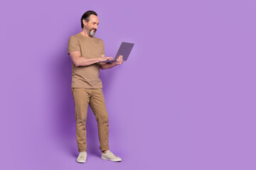 Full length photo of mature man look chat laptop report agent chief isolated over violet color...