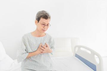 asian female patient feel tired in hospital, she use her hand touch on her chest, cardiopulmonary resuscitation, heart attack, Acute myocardial infarction, retirement healthcare