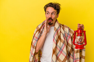 Obraz premium Young caucasian man holding lantern isolated on yellow background is saying a secret hot braking news and looking aside