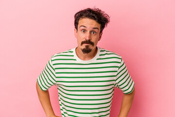Fototapeta premium Young caucasian man isolated on pink background confused, feels doubtful and unsure.