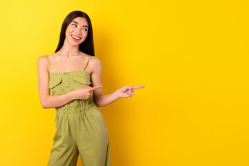 Fototapeta na wymiar Portrait of gorgeous cheerful malaysian lady look indicate fingers empty space isolated on yellow color background