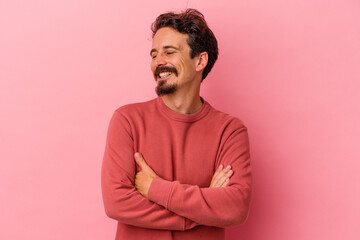 Obraz premium Young caucasian man isolated on pink background smiling confident with crossed arms.