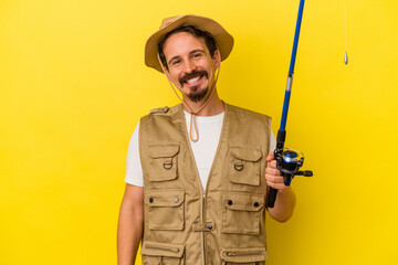 Young caucasian fisherman holding rod isolated on yellow background happy, smiling and cheerful.