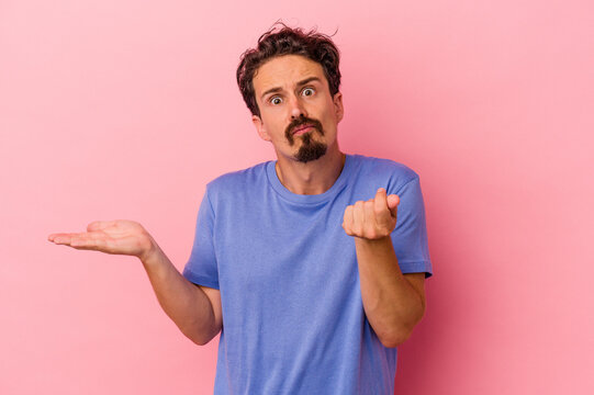 Young caucasian man isolated on pink background showing that she has no money.