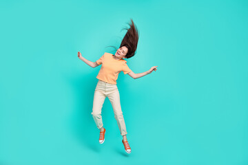 Fototapeta na wymiar Full length photo of overjoyed pretty girl jumping closed eyes flying hairdo isolated on turquoise color background