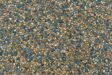 Texture of small multi-colored natural stone - river pebbles of gray and beige colors. sidewalk background. decorative coating for construction - wall and floor finishes in interiors